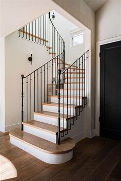 there is a staircase in the house with wooden floors and railings on both sides