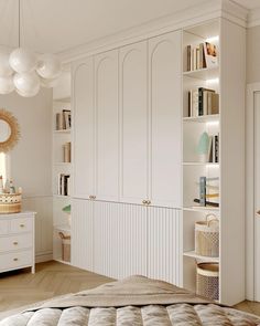 a bedroom with white furniture and lots of bookshelves in the closets area