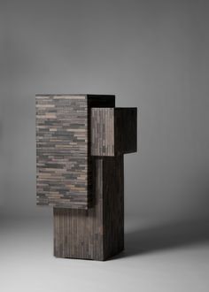 an abstract sculpture made out of wood on a gray background