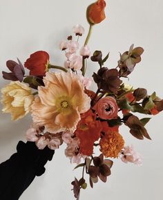 a vase filled with lots of different colored flowers