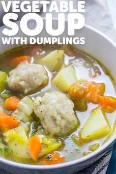 vegetable soup with dumplings in a white bowl on top of a blue towel and napkin