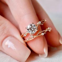 a woman's hand with a gold ring and diamond set on top of her finger