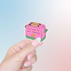 a person holding up a pink sticker with toasters on it's side