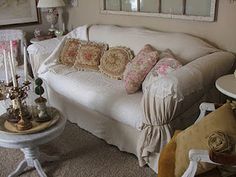 a living room filled with lots of furniture next to a wall mounted mirror on the wall