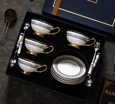 a set of four china cups and saucers in a black box with gold trimmings