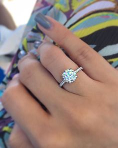 a woman's hand with a ring on her finger and a diamond in the middle