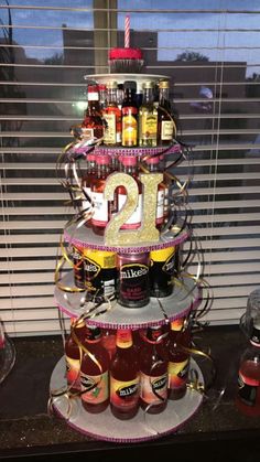 a tiered cake made to look like a 21st birthday cake with liquor bottles on it