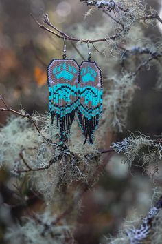 Bearheart Earrings handmade/ handbeaded by my Husband Calvin (Ojibway/Cherokee Native) The bear is known to be the cousins of many indigenous tribes of north America. The bear paw represents strength, power, humbleness, and wisdom. The black bear is a custom pattern created by my wife inspired by her knitwear and the native Zuni bear symbol, the shooting star shooting through the bear represents the bears path in life.---------------------------------------------------------------------------------------------- About me:My name is Calvin and I am an Ojibway/Cherokee native - I grew up in the wild mountains of the great northwest state of Oregon.As a true child of nature and wilderness my bead-work is strongly inspired by the wild winds, rumblings storms and wild waters I like to surround m Beaded Earrings With Bears, Bear Symbol, Wild Waters, Indigenous Tribes, Beaded Earrings Diy, Beaded Earring, Bear Paw, Bead Weaving Patterns, Earrings Diy