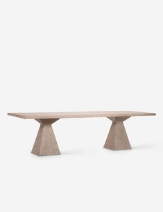 a wooden table with two legs and a white wall in the background, it is made out of concrete