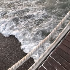 the water is choppy and foamy on the dock next to the shore line