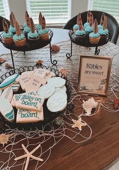 a table topped with lots of cookies and cupcakes