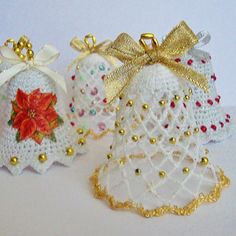 three crocheted christmas bells with bows on them, one is white and the other is gold