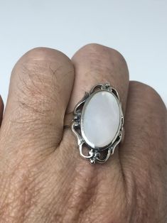 Lovely polished sterling silver has the look of Deco with a huge white Mother Of Pearl set in very detailed vintage filigree Size 7.75 We can size these with an additional $10-$20 fee for the jeweler All rings are shipped in a nice gift box. Check out our over a THOUSAND great reviews Engraving is $4 per letter and is not always perfect depending on the piece. It can take a few days if the jeweler is busy. This is payable to Paypal Judithsltd@gmail.com Silver Filigree Ring With Polished Finish For Wedding, White Moonstone Ring With Polished Finish, Antique White Oval Moonstone Ring, Antique White Moonstone Ring, Classic White Oval Cabochon Ring, White Oval Cabochon Ring As Gift, White Oval Cabochon Ring For Gift, Heirloom White Moonstone Ring For Formal Occasions, Formal White Rings With Intricate Design