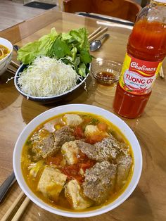 a bowl of soup with meat and vegetables on the table