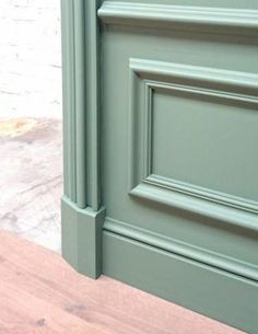 a close up of a green door on a wooden floor