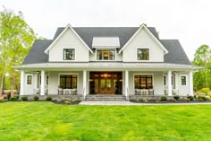 a large white house sitting on top of a lush green field