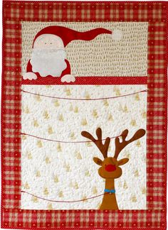 a red and white quilted wall hanging with santa clause on it