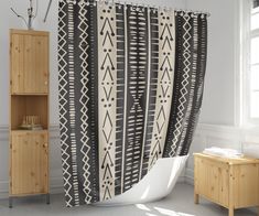 a bathroom with a black and white shower curtain next to a wooden cabinet in the corner