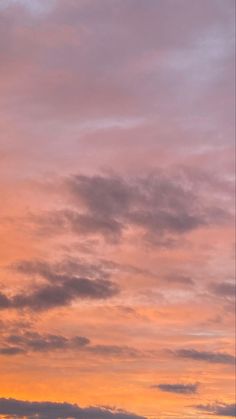 an airplane is flying in the sky at sunset