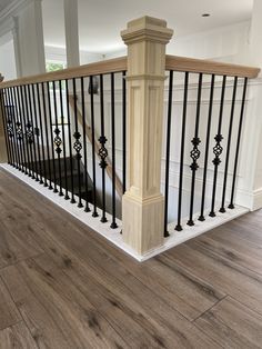 a staircase with black iron railings and wood flooring