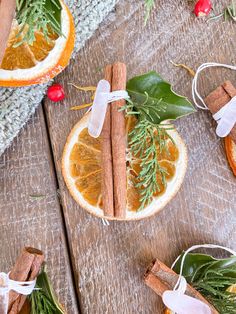 an orange slice with cinnamon sticks on top of it, surrounded by other pieces of fruit and greenery