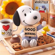 a snoopy figurine holding a good morning sign