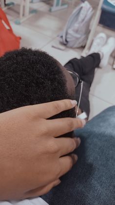 a person sitting down with their hands on the back of his head