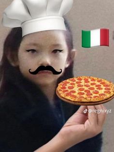 a woman holding a pizza with a mustache on it's head and an italian flag in the background