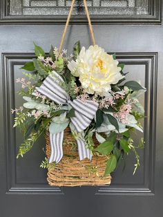 a basket with flowers hanging on the front door