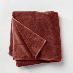 two towels folded on top of each other, one is red and the other is brown