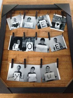 an old photo frame with clothes pins attached to it and photos hanging on the clothes pegs