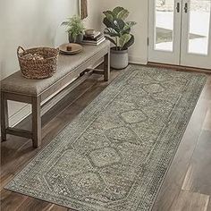 a large area rug is on the floor in front of a entryway with a bench and potted plant