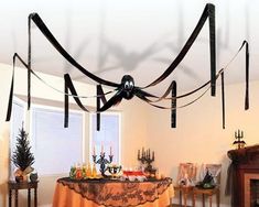 a dining room with a table covered in black ribbon and candles on the fireplace mantel