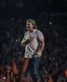 a man standing on top of a stage surrounded by people