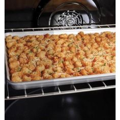 a pan filled with tater tots sitting on top of an oven