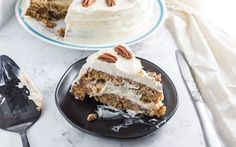 two slices of carrot cake on black plates with one slice cut out and the other half eaten