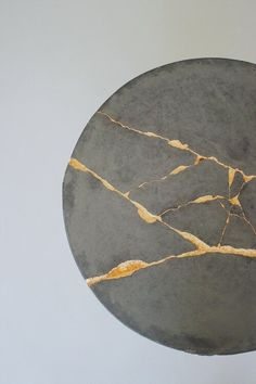 a black and gold marbled round table with white walls in the backround