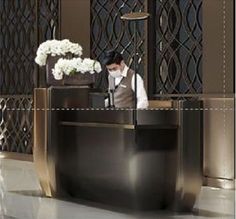 a man standing at the front desk of a hotel