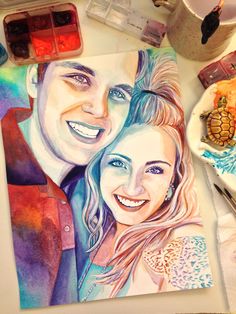 a watercolor painting of a couple next to paintbrushes and paints on a table