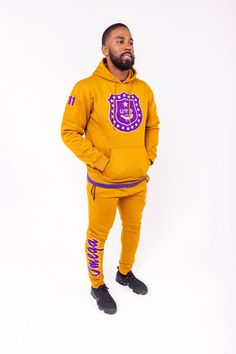 This gold Omega Psi Phi jogging suit will fit right into your athletic leisure wear. The chest is fully embroidered with the Omega Psi Phi badge along with the sleeves being fully embroidered as well with 1911 on one sleeve and gold boots on the other. The hood has OMEGA embroidered in chenille letters which sits upright when hood is not being worn across the upper back. The pants are comfortable with zippers on the pockets to secure your essentials. The pants are embroidered with the gold boots, as well as OMEGA in chenille letters along the right calf. The adjustable waistband also lets you customize the fit for maximum comfort. Elastic waistband with drawstring Embroidered fabric applique with raised details Inseam for size L measures approximately 30'' Two zippered side pockets 100% Co Omega Man, Gold Boots, Omega Psi Phi, Fabric Applique, Jogging Suit, Embroidered Fabric, Adjustable Waistband, Leisure Wear, Halloween Shopping