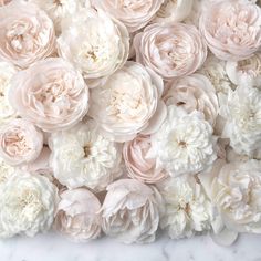 a bunch of pink and white flowers on a marble surface