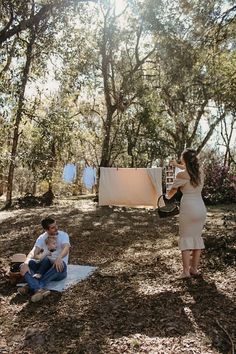 a man and woman are sitting in the woods