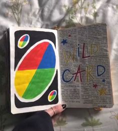 an open book with the words wild card written in rainbow colors and stars on it