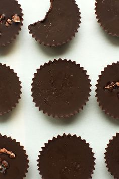 chocolates are arranged in rows on a white surface with walnuts and other nuts