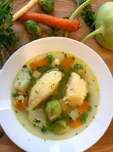 a white bowl filled with soup next to vegetables