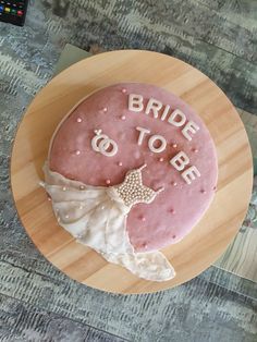 a bride to be cake sitting on top of a wooden plate