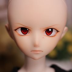 a close up of a doll with red eyes