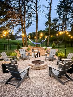 a fire pit surrounded by lawn chairs and string lights