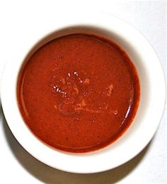 a white bowl filled with red soup on top of a table