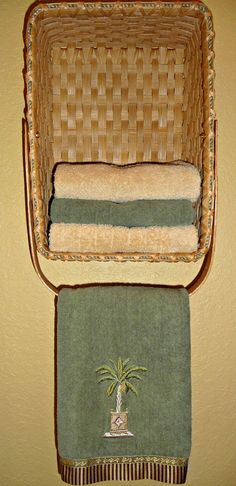 a wicker chair with two towels and a towel rack on the wall above it